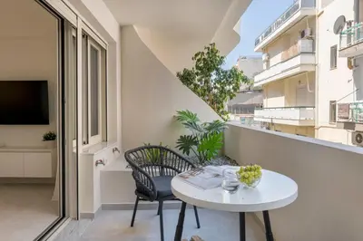 a small white table and chair on a balcony at Boutique Studio ΙV in Central Athens by MPS in Athens