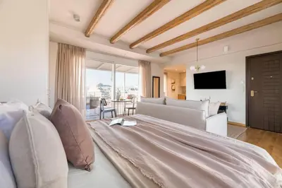 a bedroom with a large bed and a living room at Panoramic Acropolis View Rooftop Studio by MPS in Athens