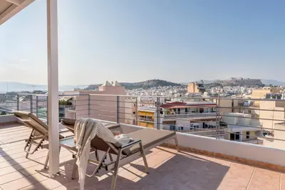 a balcony with a table and chairs on a roof at Panoramic Acropolis View Rooftop Studio by MPS in Athens
