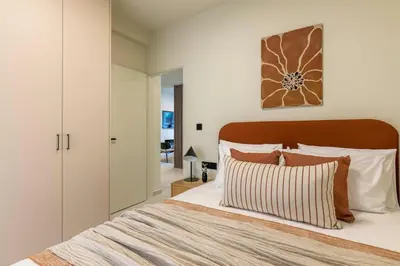 a bedroom with a large bed with white walls at Piraeus Terra Residence - Family 2 BDRM by MPS in Piraeus