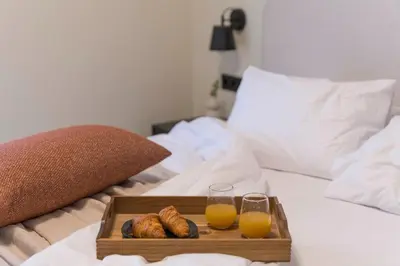 a tray of croissants and glasses of orange juice on a bed at Piraeus Terra Residence - Family 2 BDRM by MPS in Piraeus