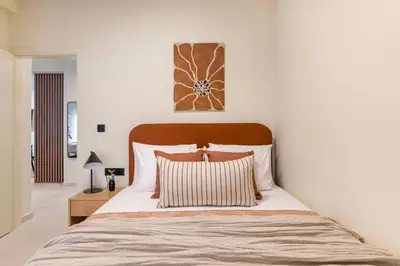 a bedroom with a large bed with a wooden headboard at Piraeus Terra Residence - Family 2 BDRM by MPS in Piraeus