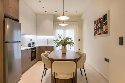 a kitchen with a table with chairs and a refrigerator at Piraeus Terra Residence - Family 2 BDRM by MPS in Piraeus