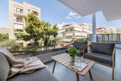 a balcony with a couch and chairs and a table at Elliniko Riviera - 2BDRM Apt - Near Metro by MPS in Athens
