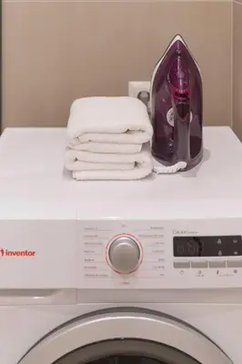 a washing machine with towels on top of it at Elliniko Riviera - 2BDRM Apt - Near Metro by MPS in Athens
