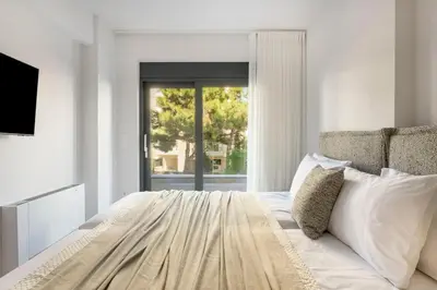 a white bedroom with a large bed and a window at Elliniko Riviera - 2BDRM Apt - Near Metro by MPS in Athens