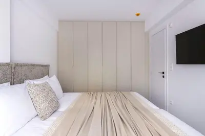 a bedroom with a bed and a tv on a wall at Elliniko Riviera - 2BDRM Apt - Near Metro by MPS in Athens