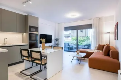 a kitchen and living room with a couch and a table at Elliniko Riviera - 2BDRM Apt - Near Metro by MPS in Athens