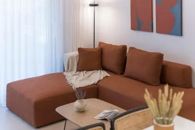 a living room with a brown couch and a table at Elliniko Riviera - 2BDRM Apt - Near Metro by MPS in Athens