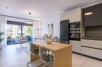a kitchen and dining room with a wooden table and chairs at Elliniko Riviera - Family Apt Near Metro by MPS in Athens