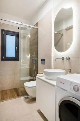 a bathroom with a toilet sink and a washing machine at Elliniko Riviera - Family Apt Near Metro by MPS in Athens