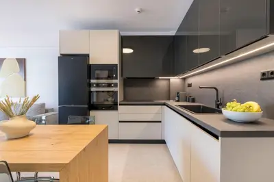 a kitchen with white cabinets and a bowl of fruit on a counter at Elliniko Riviera - Family Apt Near Metro by MPS in Athens