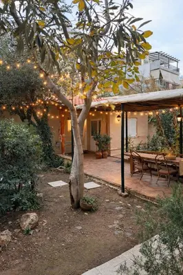 a patio with a tree with lights on it at Cosy House With Garden Glyfada in Athens