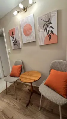 a room with two chairs and a table and paintings at Cosy House With Garden Glyfada in Athens