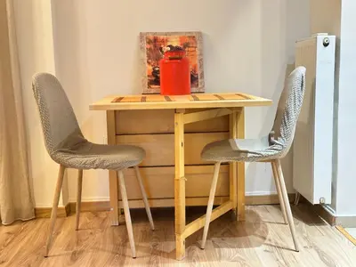 a table with two chairs and a red container on it at Cosy House With Garden Glyfada in Athens