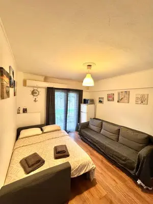 a bedroom with a bed and a couch at Athenian Riviera beach apartment in Athens