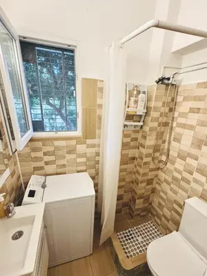 a bathroom with a shower and a toilet and a sink at Athenian Riviera beach apartment in Athens