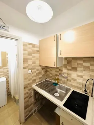 a kitchen with a sink and wooden cabinets at Athenian Riviera beach apartment in Athens