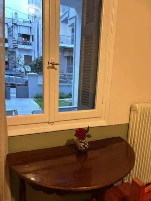 a table and a window with a rose on it at Private room for 3 in a dorm 5' from metro in Athens