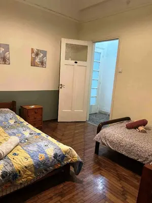 a room with two beds and a door to a bedroom at Private room for 3 in a dorm 5' from metro in Athens