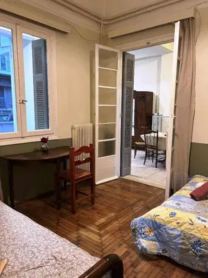 a bedroom with a bed and a desk and a table at Private room for 3 in a dorm 5' from metro in Athens