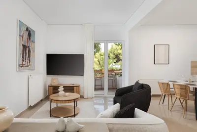 a living room with a couch and a table at Thalè Residence Varkiza in Vari