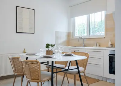 a kitchen with a table with chairs and a sink at Thalè Residence Varkiza in Vari