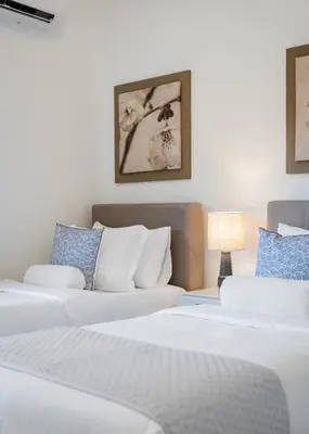 a hotel room with two beds and a couch at Thalè Residence Varkiza in Vari