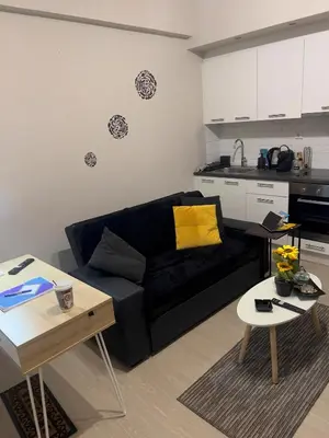 a living room with a black couch and a kitchen at #Greek Homely Space Βy Marianthi - In the heart of Athens in Athens