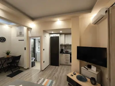 a living room with a flat screen tv on a wall at Cozy Harbor Studio Just 3 min from Piraeus Port in Piraeus