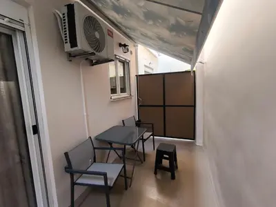 a room with a table and chairs and a tv at Cozy Harbor Studio Just 3 min from Piraeus Port in Piraeus