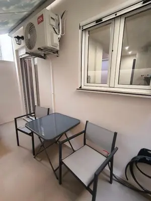 a room with a table and two chairs and a fan at Cozy Harbor Studio Just 3 min from Piraeus Port in Piraeus