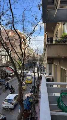 a balcony of a building with a tree and a street at Kassandra lovely floor appartment in Patriarchou Ioakim the heart of Kolonaki in Athens
