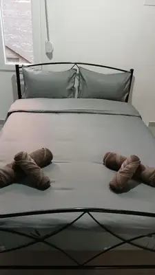 a bed with two pairs of shoes on it at Athens Apartments, Piraeus Port in Athens