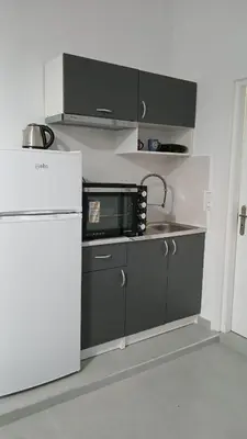 a small kitchen with a microwave and a refrigerator at Athens Apartments, Piraeus Port in Athens