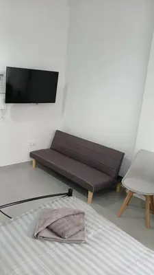 a bedroom with a bed and a flat screen tv at Athens Apartments, Piraeus Port in Athens
