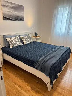 a bedroom with a bed with a blue comforter at Seaview Jazmin Nest in Athens