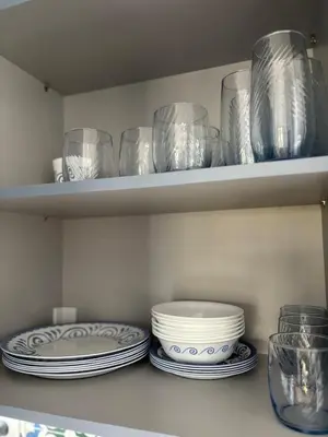 a shelf filled with plates and bowls and glasses at Seaview Jazmin Nest in Athens