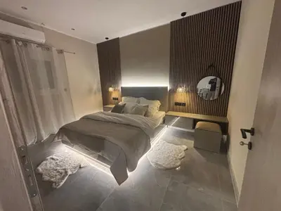 a bedroom with a bed and two rugs on the floor at Athens Air B&B in Athens