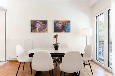 a white dining room with a table and chairs at White Harmony - 2BD Apt close to metro in Athens