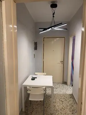 a white table and chairs in a room with a door at illusion 2 in Piraeus