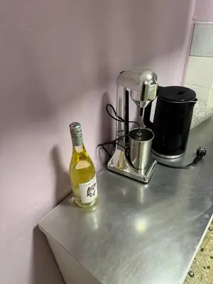 a bottle of wine sitting on a counter next to a blender at illusion 2 in Piraeus