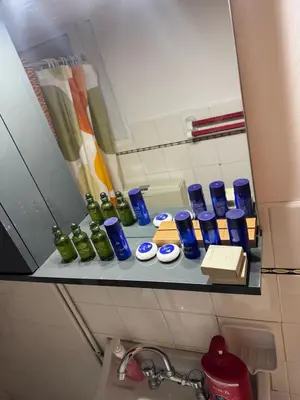 a shelf with blue and green glass bottles on it at illusion 2 in Piraeus