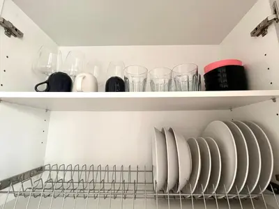 a shelf with glasses and plates on it at Hellenic Coastal Residence in Athens