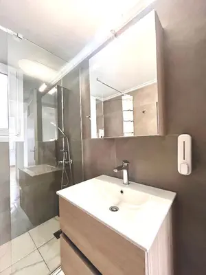 a bathroom with a sink and a mirror and a shower at Hellenic Coastal Residence in Athens