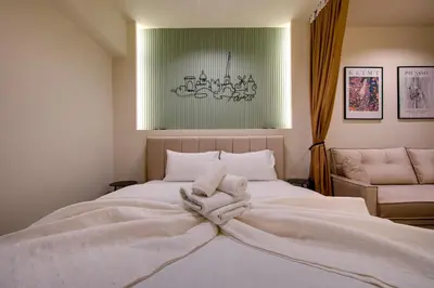 a bedroom with a large bed with white blankets and pillows at Sweet Dispotition-Modern ground flat next to metro in Athens