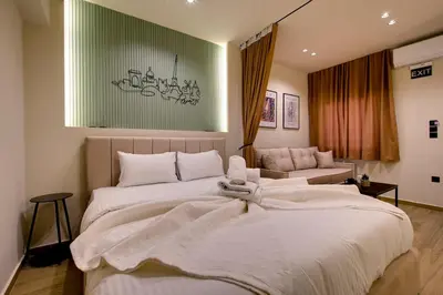 a bedroom with a large white bed and a couch at Sweet Dispotition-Modern ground flat next to metro in Athens