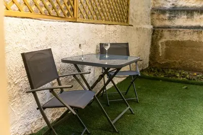 two chairs and a table with two wine glasses on it at Sweet Dispotition-Modern ground flat next to metro in Athens