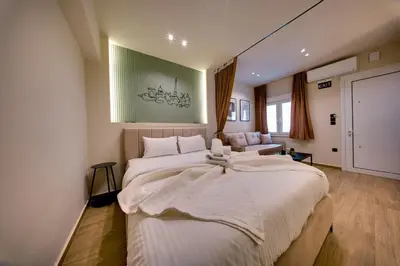 a bedroom with a large white bed and a couch at Sweet Dispotition-Modern ground flat next to metro in Athens