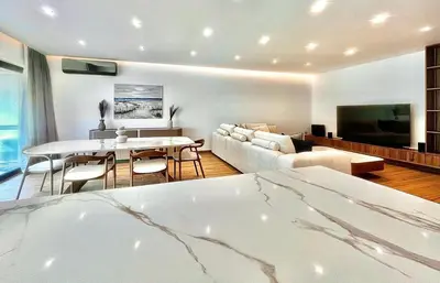 a living room with a couch and a table and a tv at Sealine Spacious Apartment in Athens